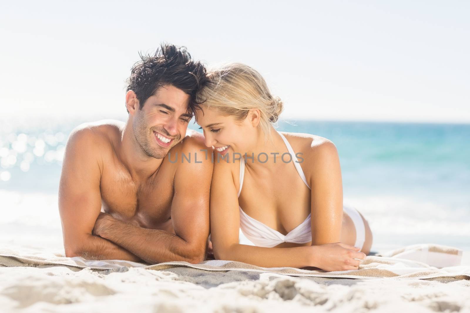 Romantic young couple lying on beach