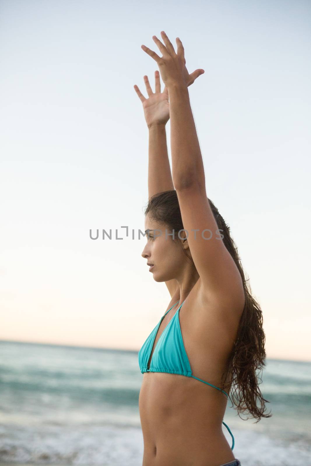 Young woman performing yoga on the beach