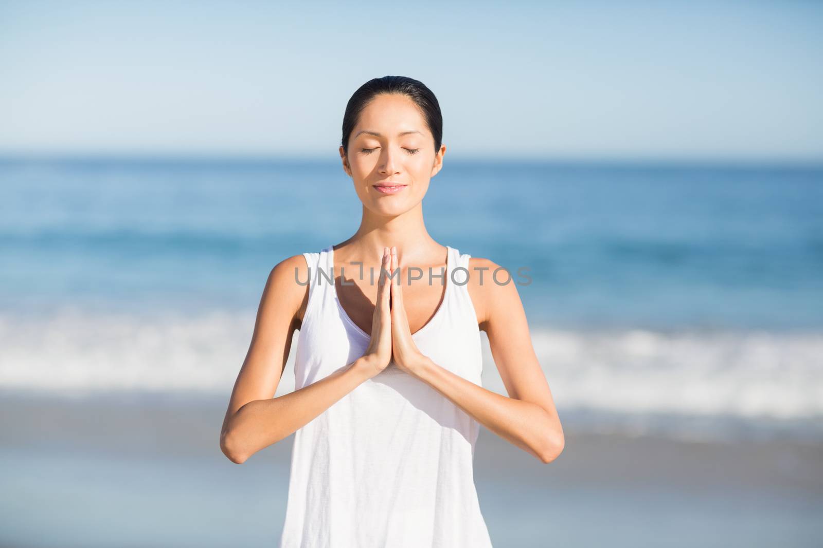 Young woman performing yoga on beach