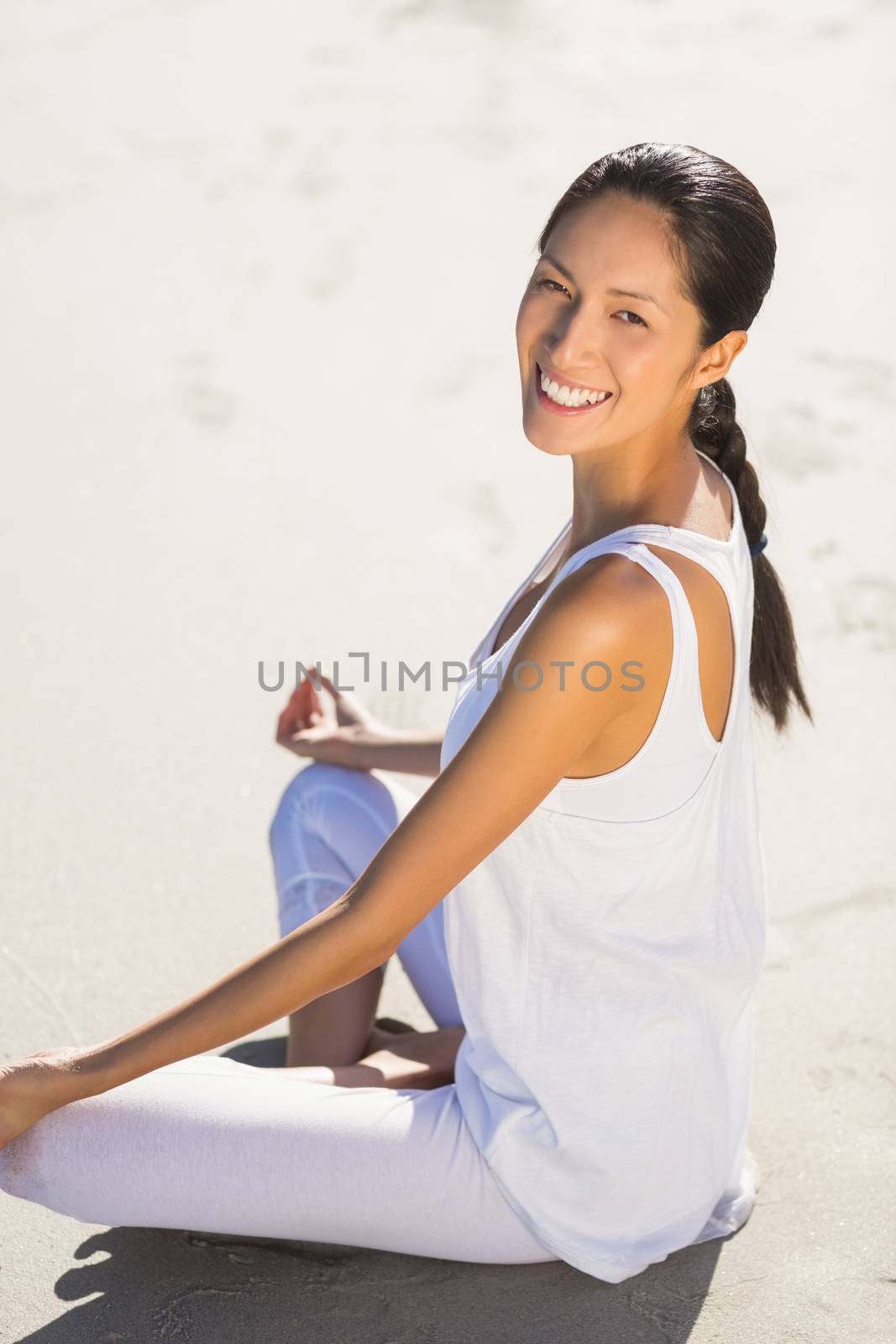 Portrait of beautiful woman performing yoga on the beach