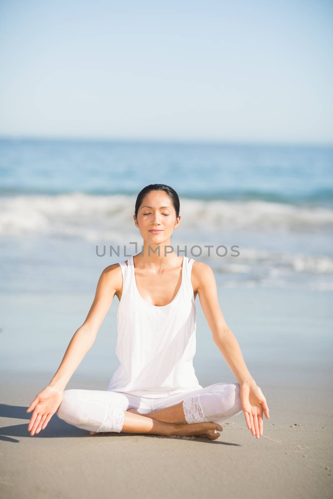 Woman performing yoga on the beach