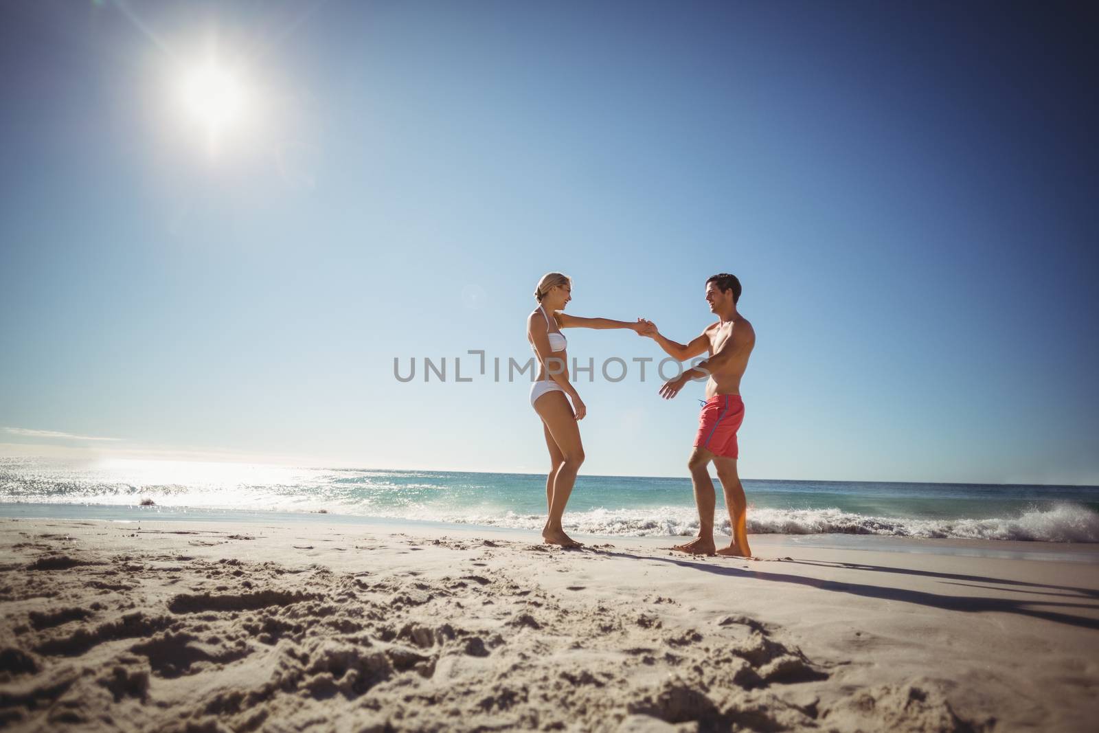 Romantic couple dancing on beach in summer