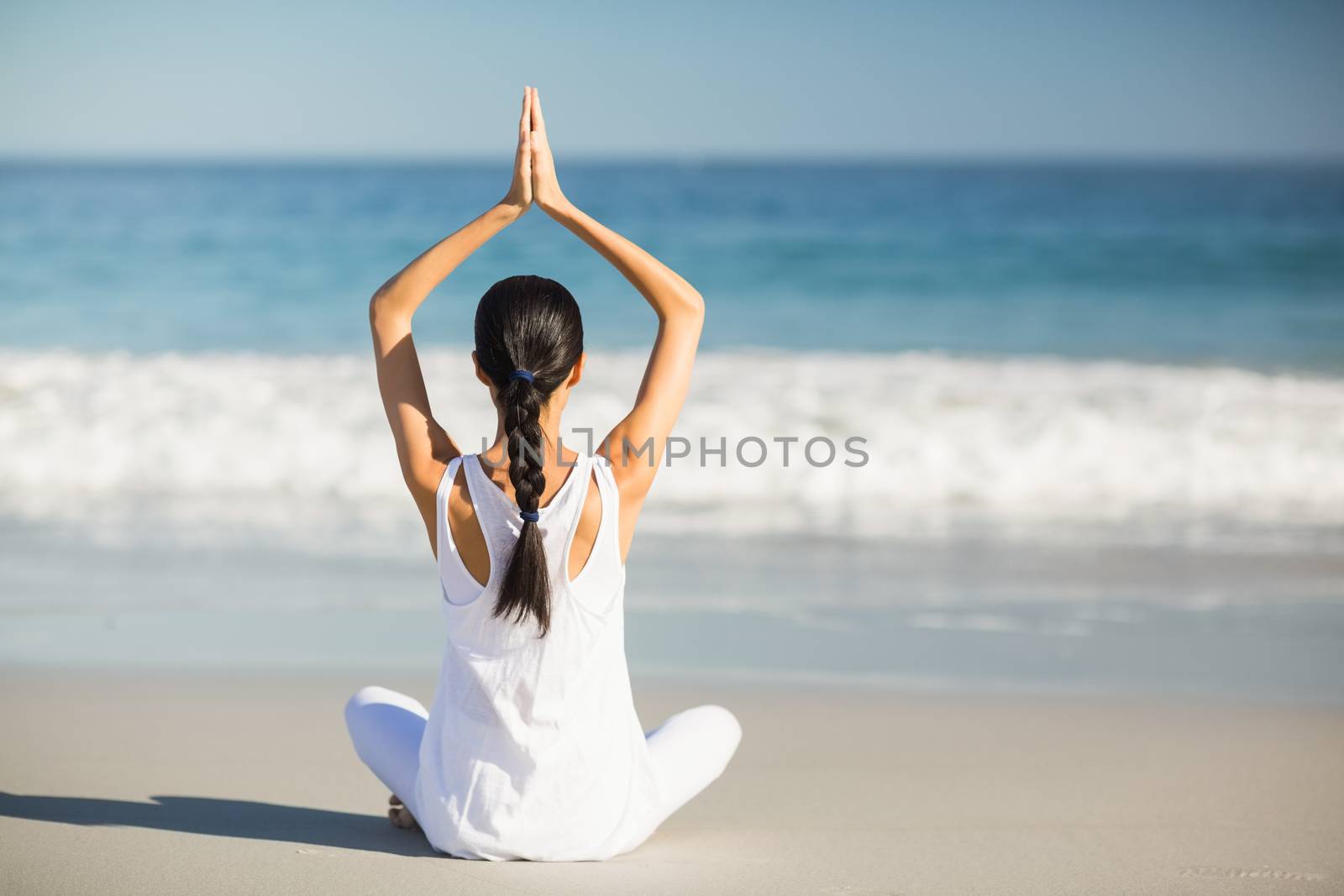 Woman performing yoga on the beach