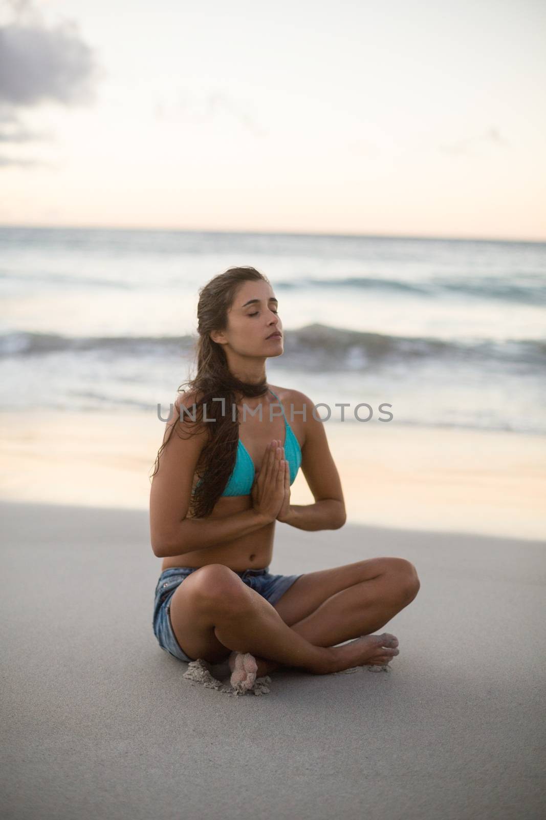 Young woman performing yoga on the beach
