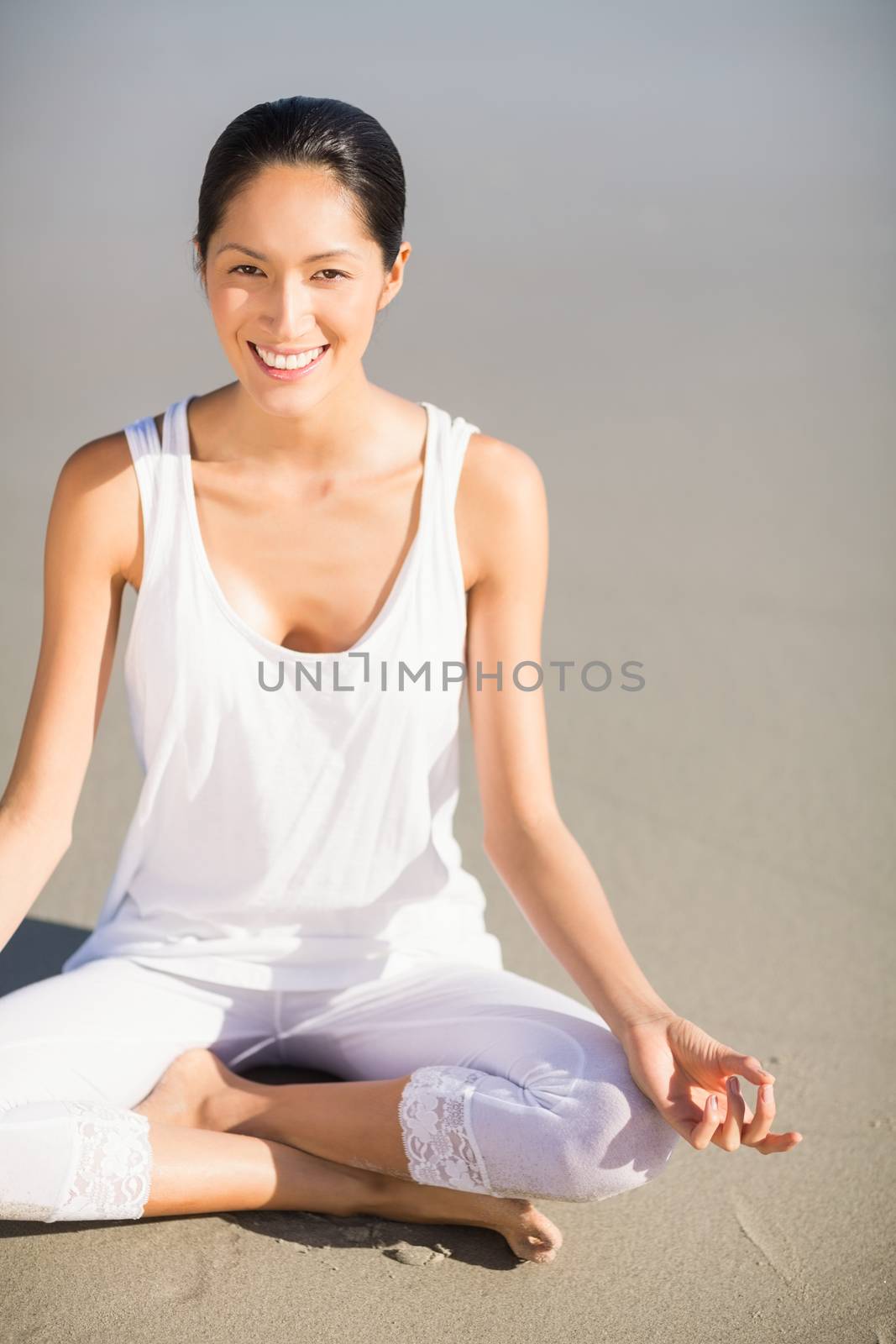 Portrait of woman performing yoga on the beach 