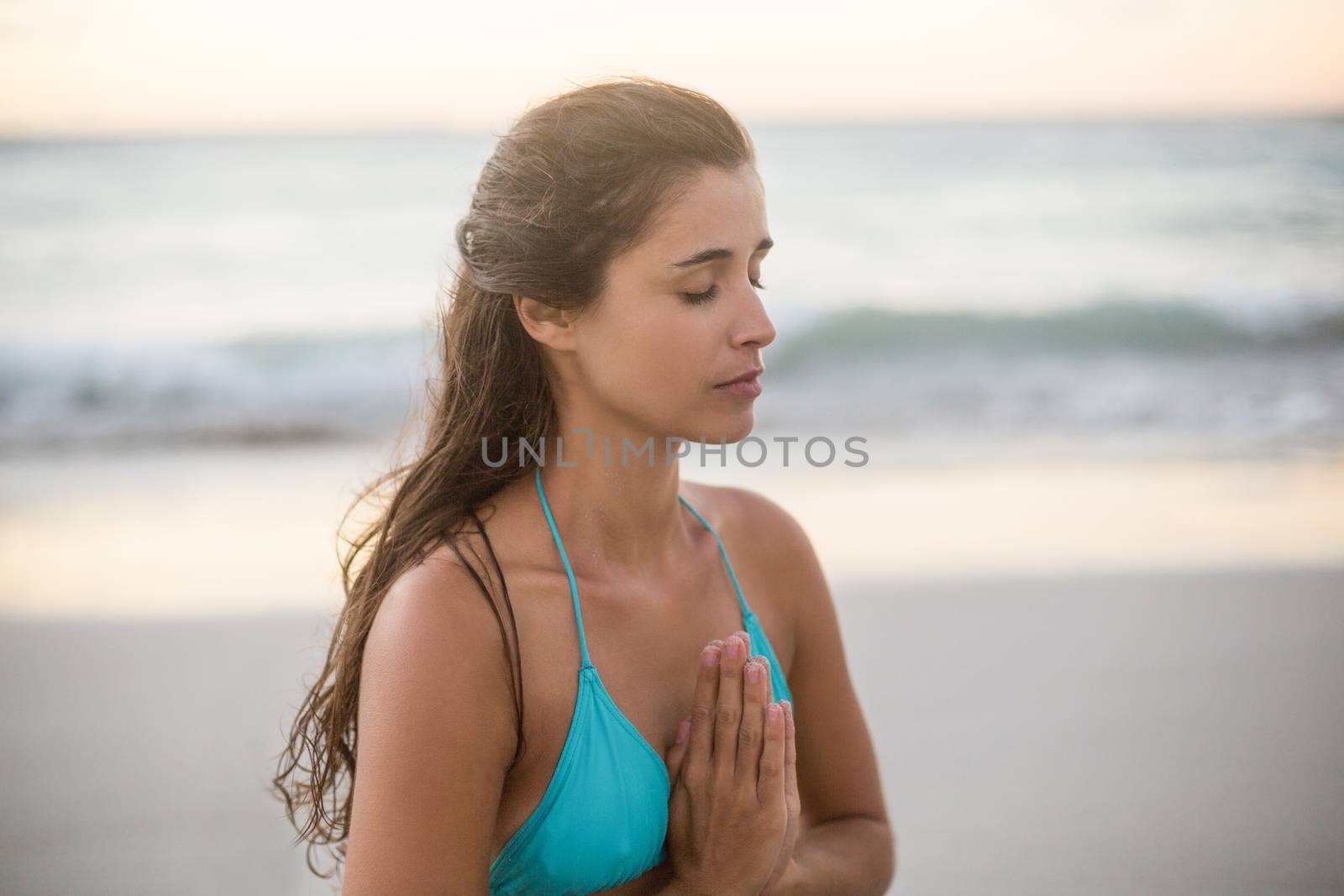 Young woman performing yoga on the beach