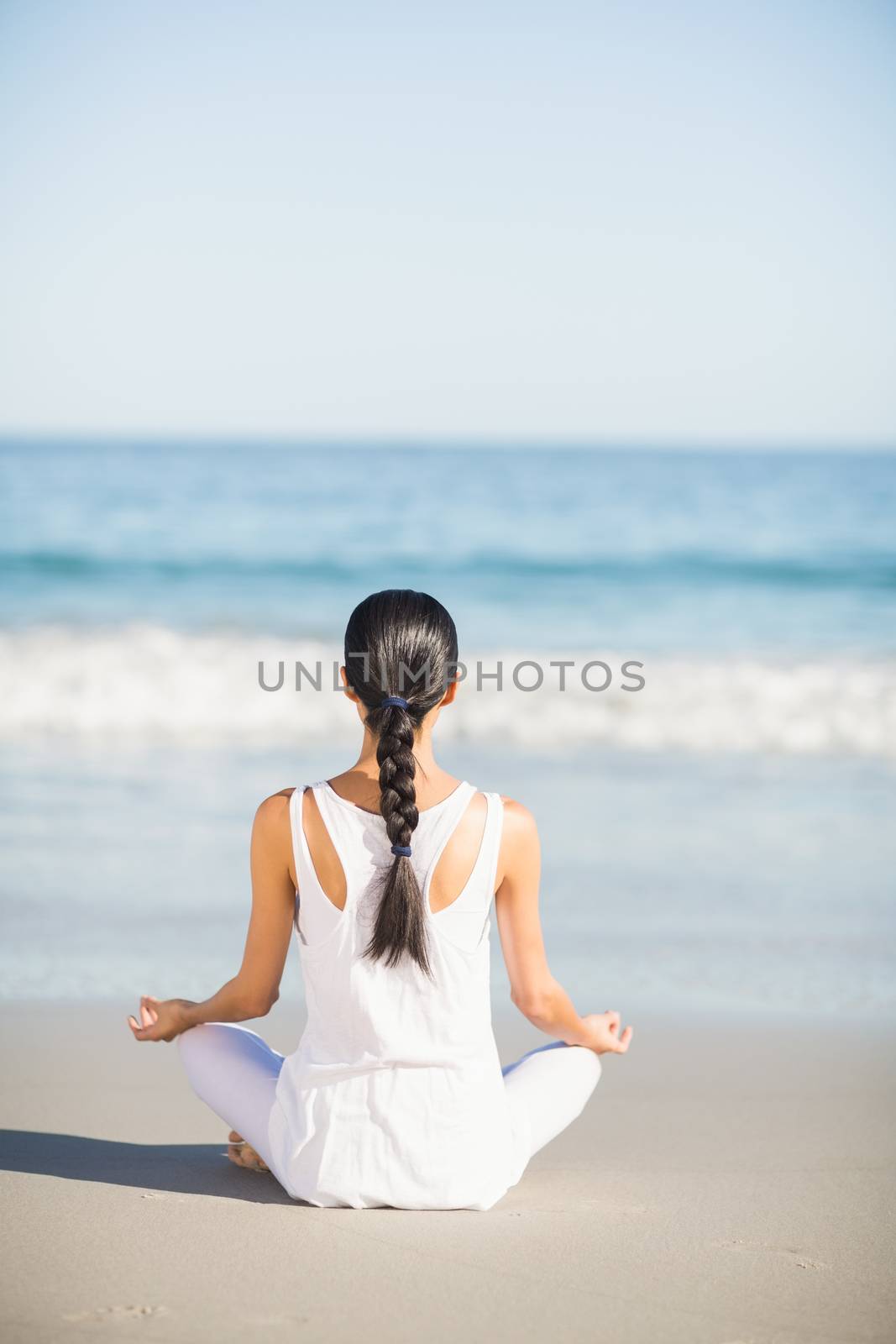 Young woman performing yoga on the beach