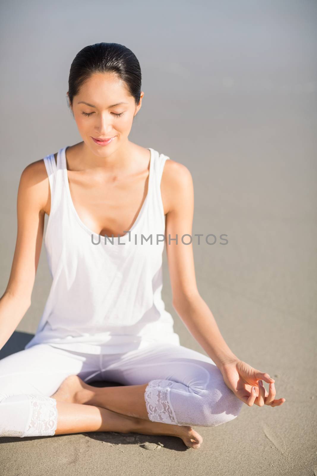 Woman performing yoga on the beach