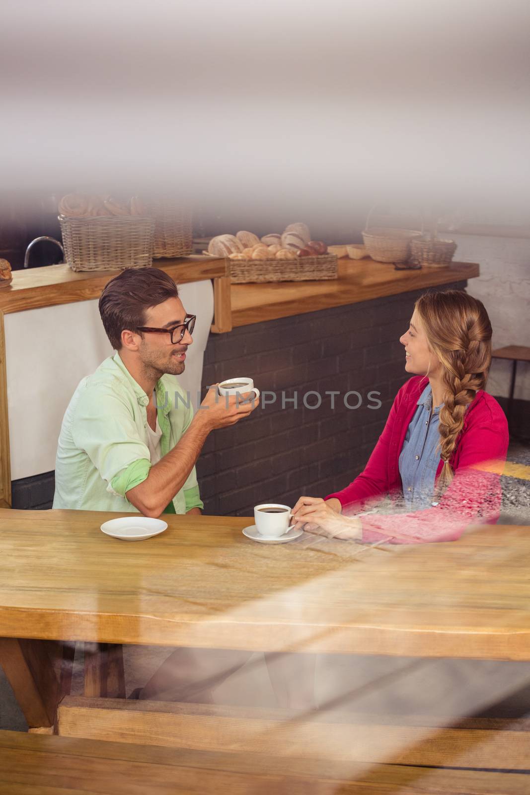 Couple interacting while drinking a coffee by Wavebreakmedia