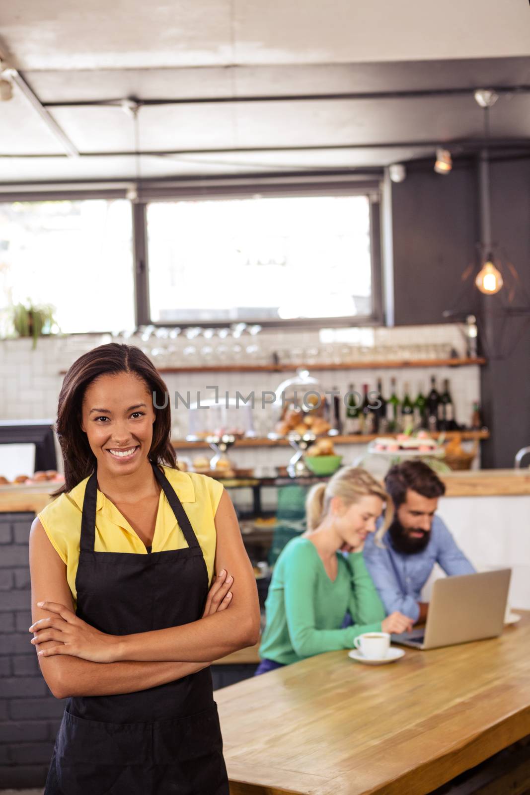 Waitress standing with arms crossed in a cafe