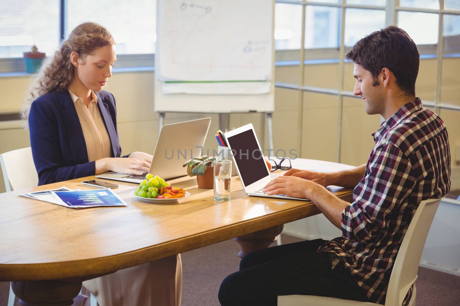 Business people using laptop at work