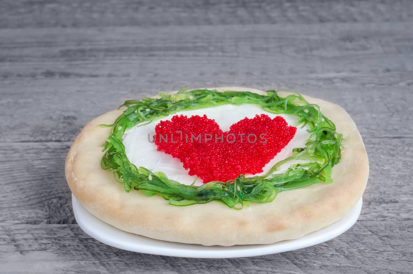 Sandwich with seaweed and caviar on a gray wooden background