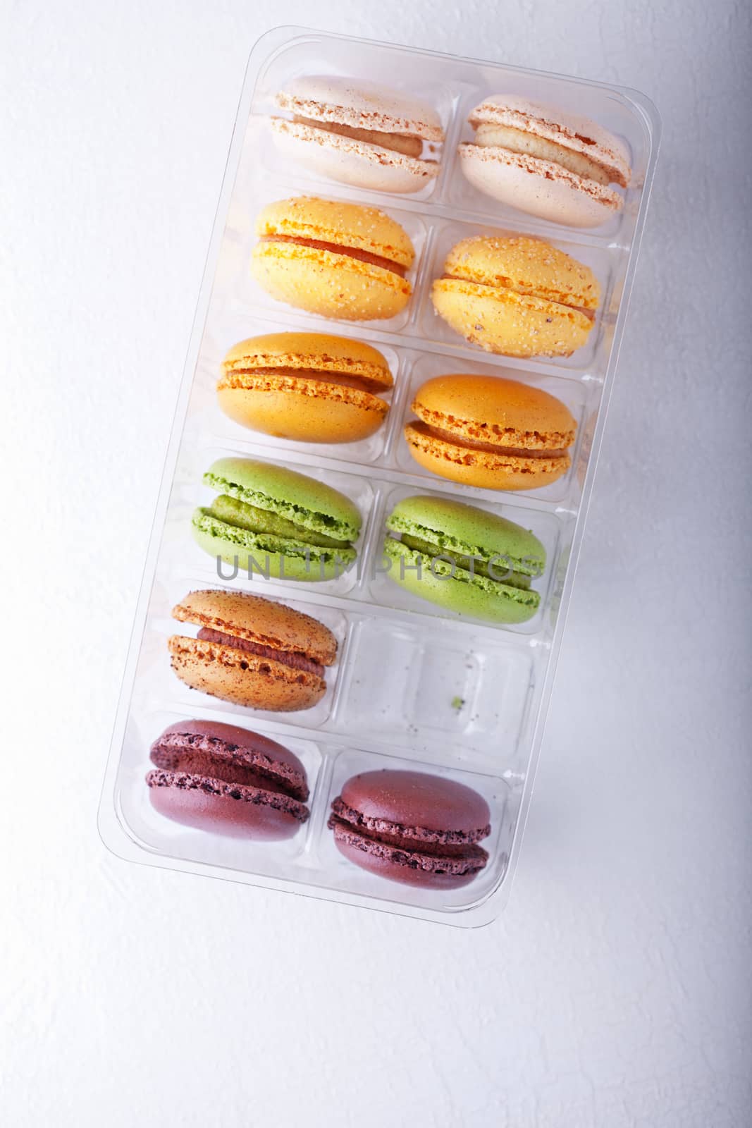 Multicolored Macarons in Box placed on a white background