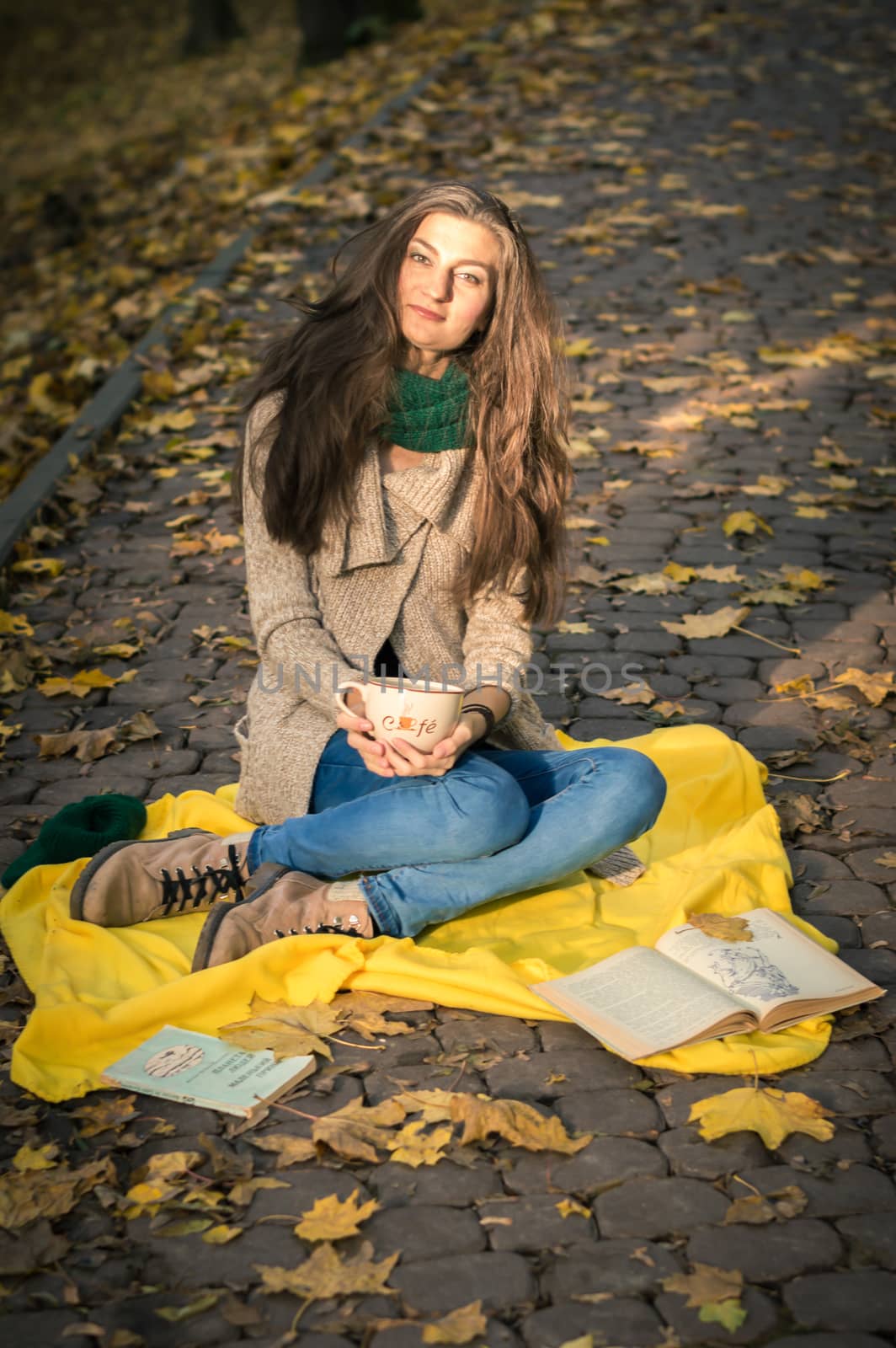 girl with a cup of coffee sitting in autumn Park