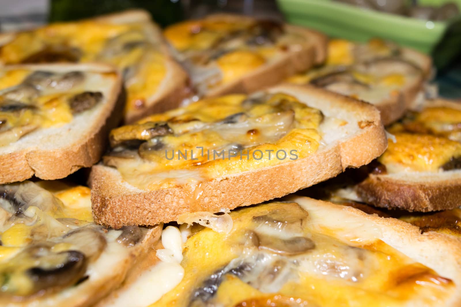 Slices of toasted white bread and seasoned with mushrooms, cheese and egg