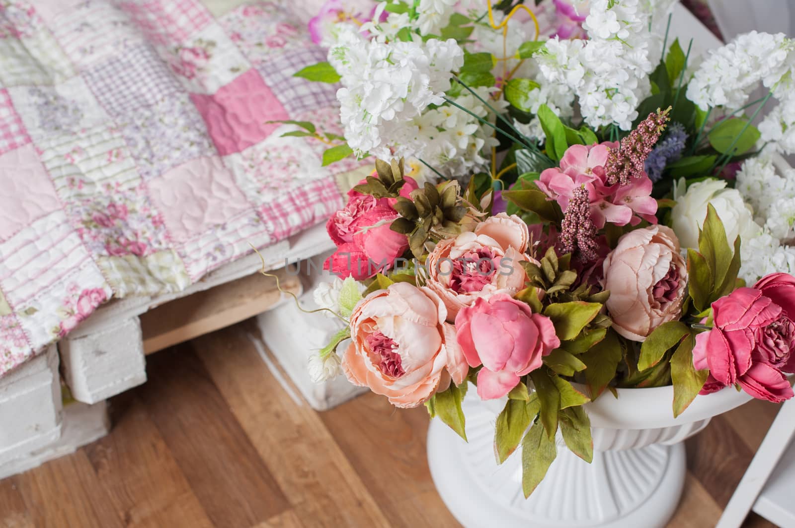 bouquet of pink flowers in a vase near the bed.