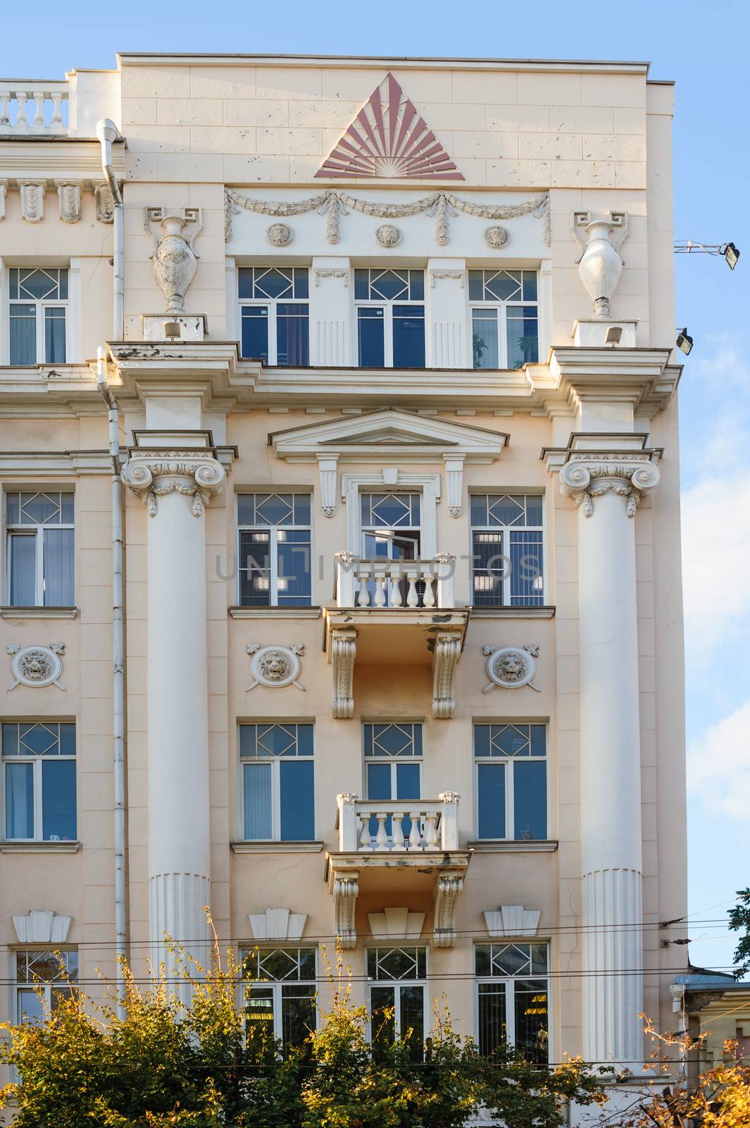 facade of an old building with white columns and balconies.