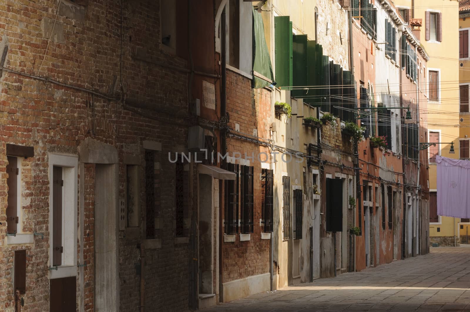 Narrow cobblestone alley in the historical center of Venice, Veneto, Italy, Europe