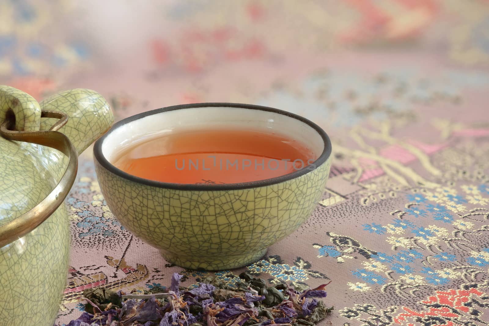 cup with tea on a beautiful tablecloth and a pinch  flower tea