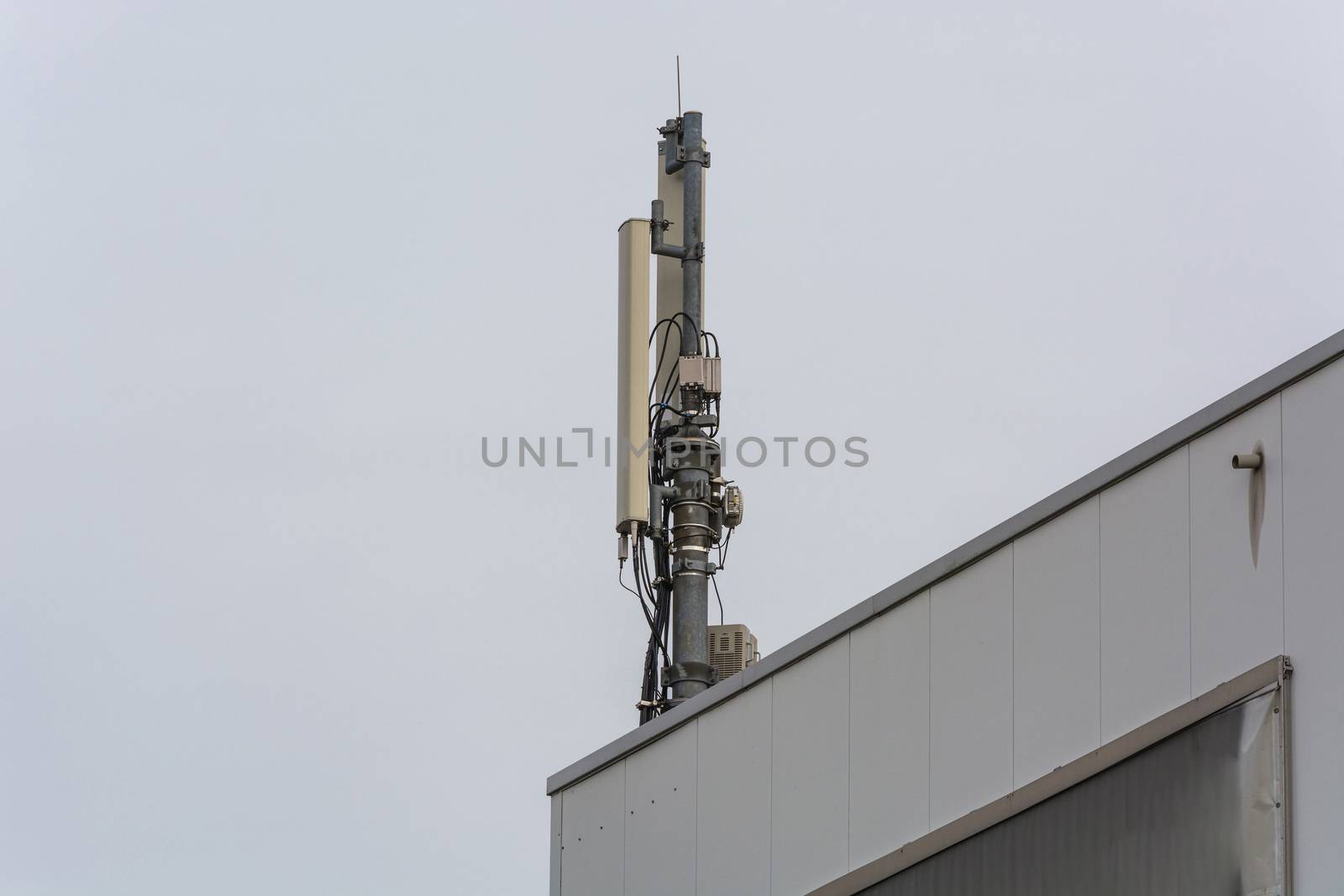 Antenna, telecommunications tower on a roof, wireless telecommunications concept.