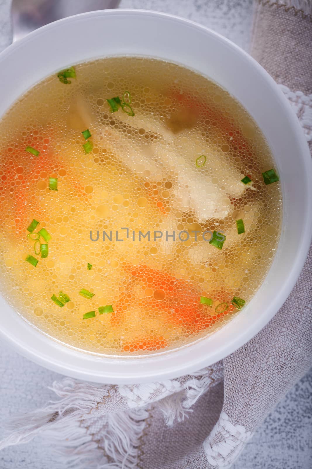Homemade chicken soup served on a table