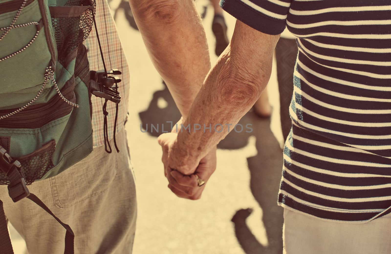Elderly couple of tourists holding hands. by dmitrimaruta
