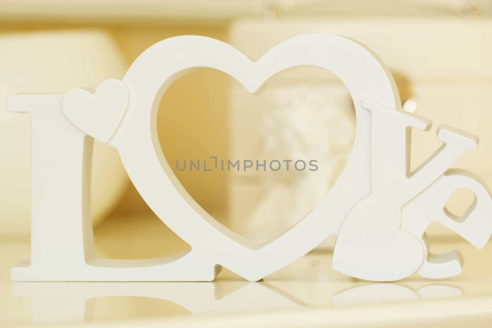 Wooden letters forming word LOVE written with angel on background