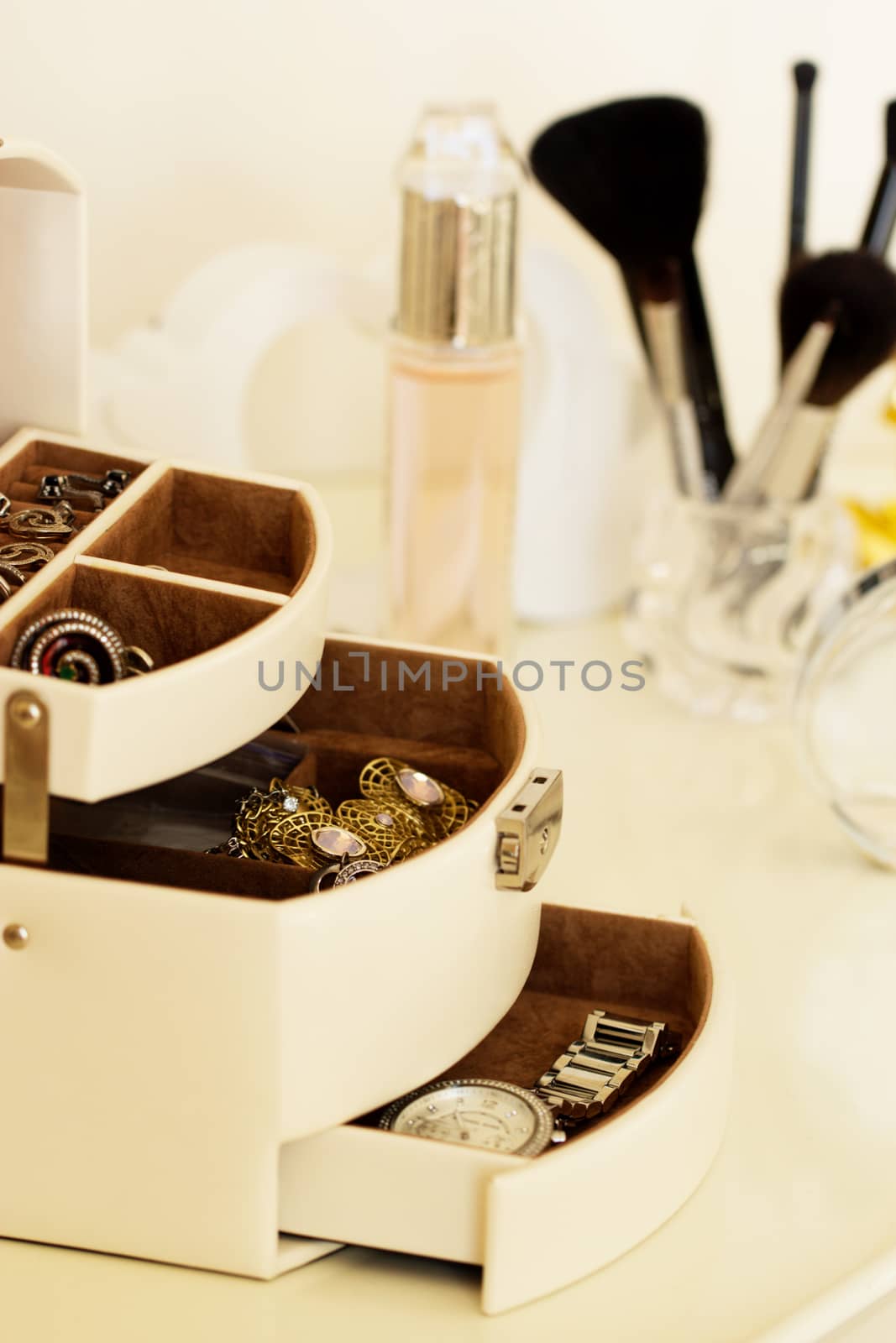dressing table with women's accessories. perfume, jewelry and makeup brushes on a  table, close-up