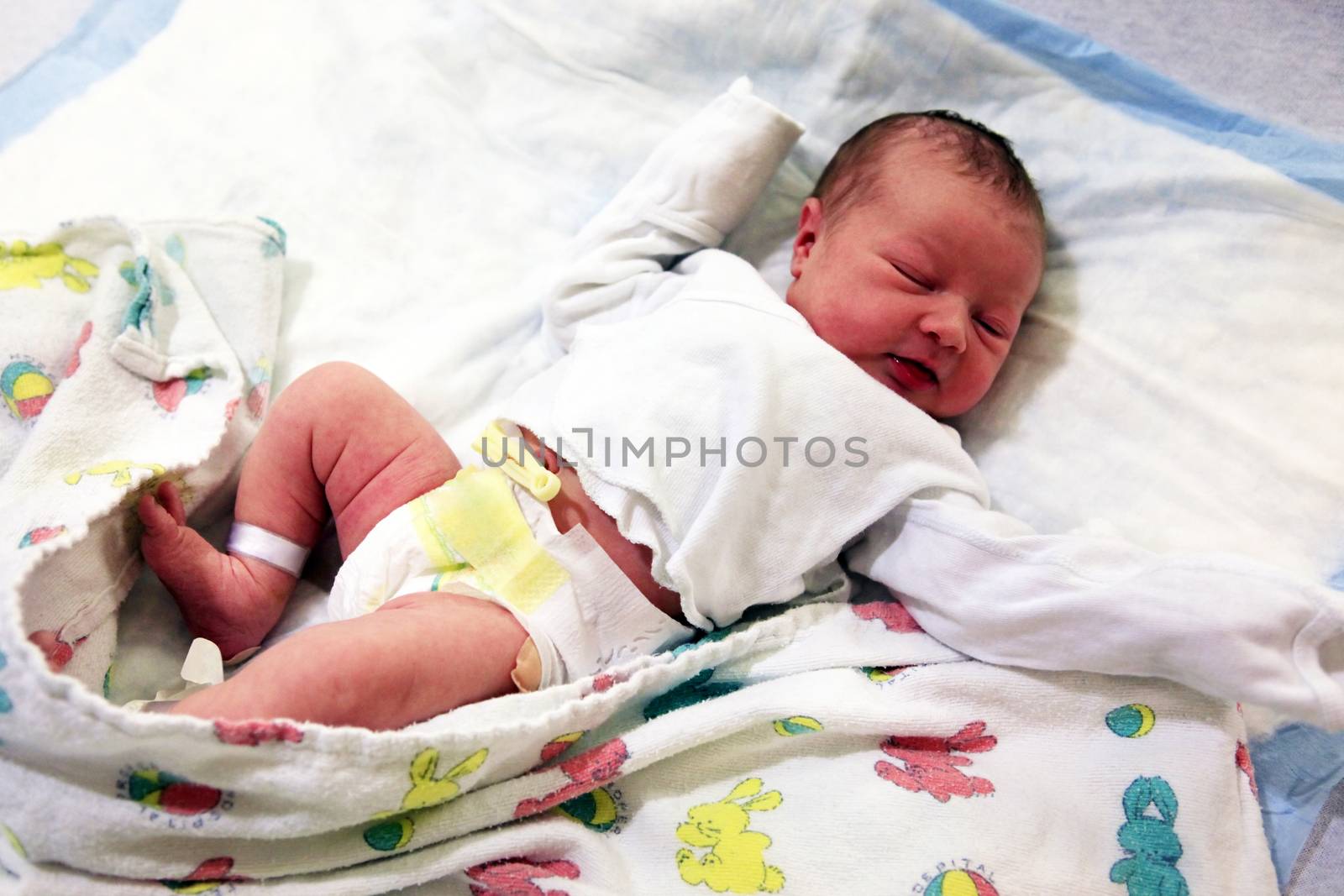 Sleeping newborn baby in the arms of my mother in hospital