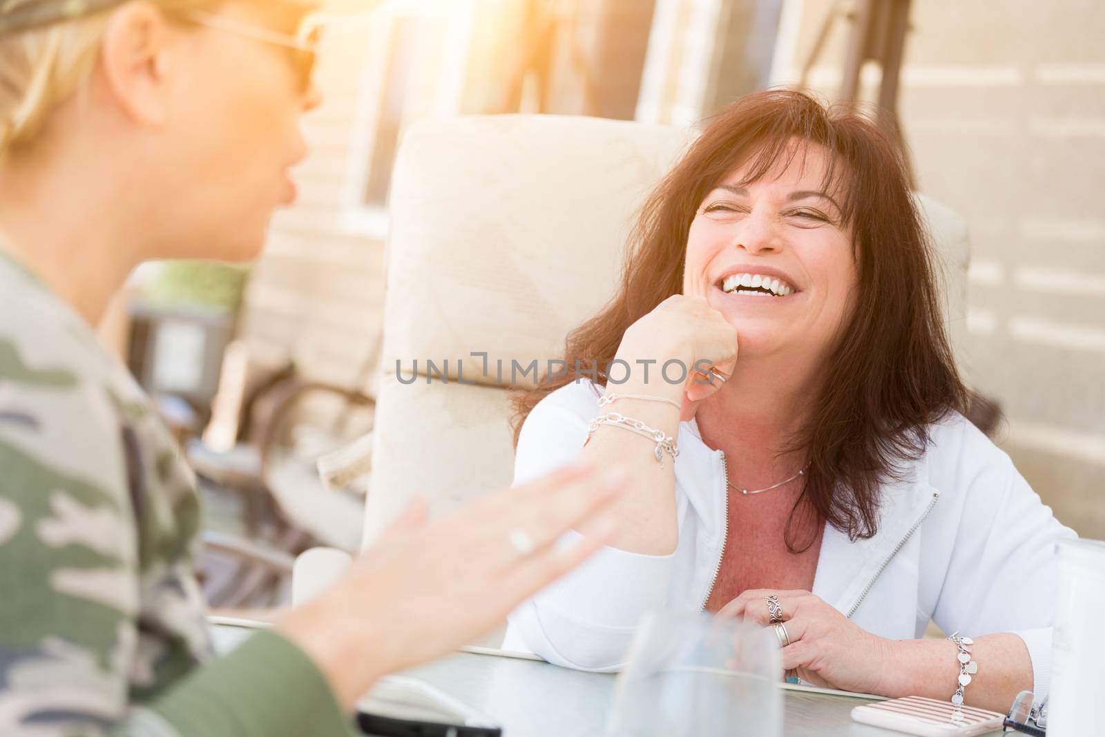 Two Female Friends Enjoying Conversation Outside by Feverpitched