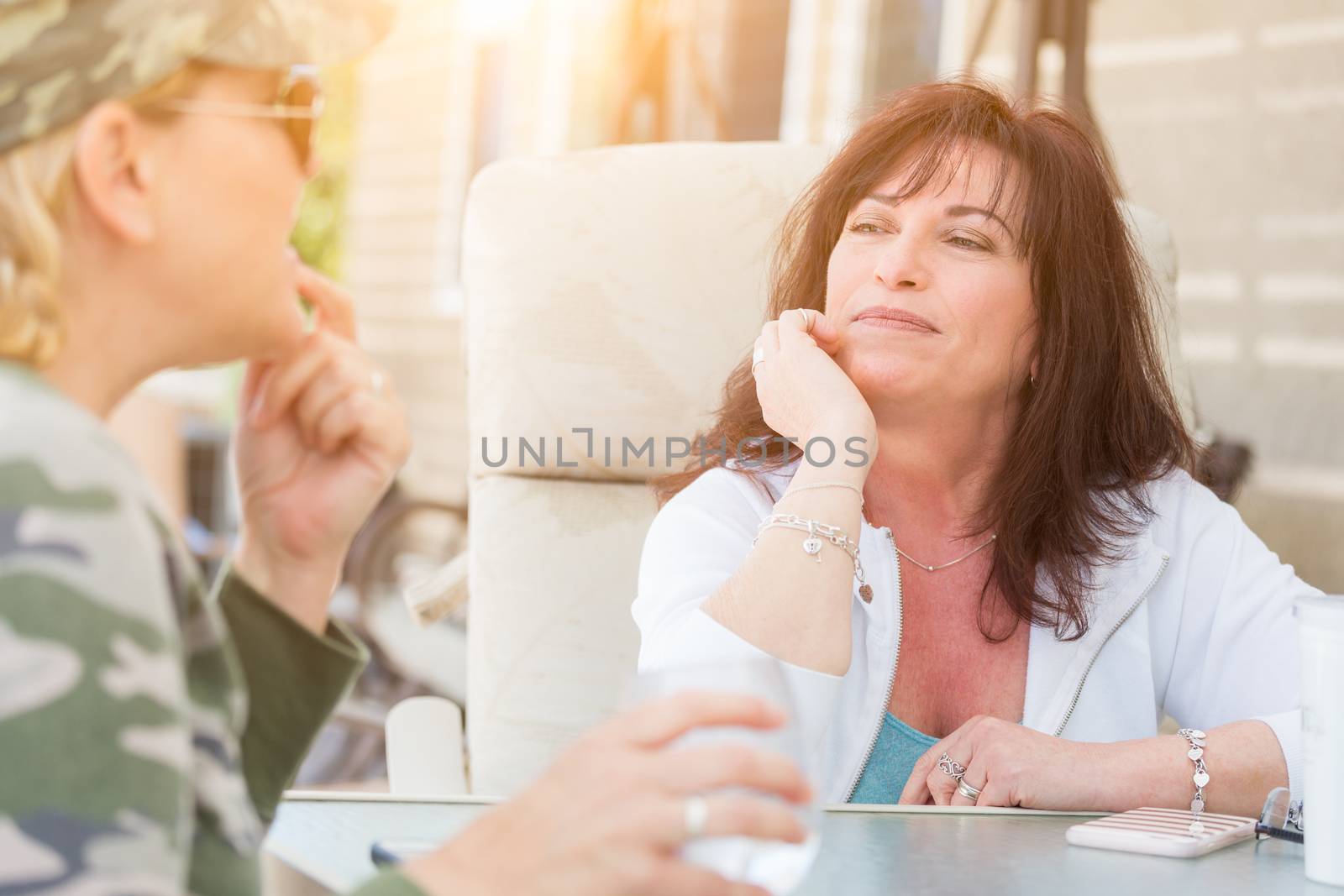 Two Female Friends Enjoying Conversation Outside by Feverpitched