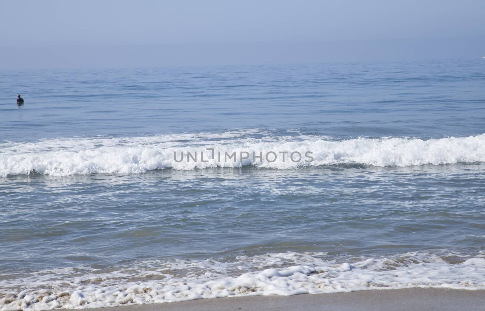 Heavy, foamy waves lapping at the ocean shore