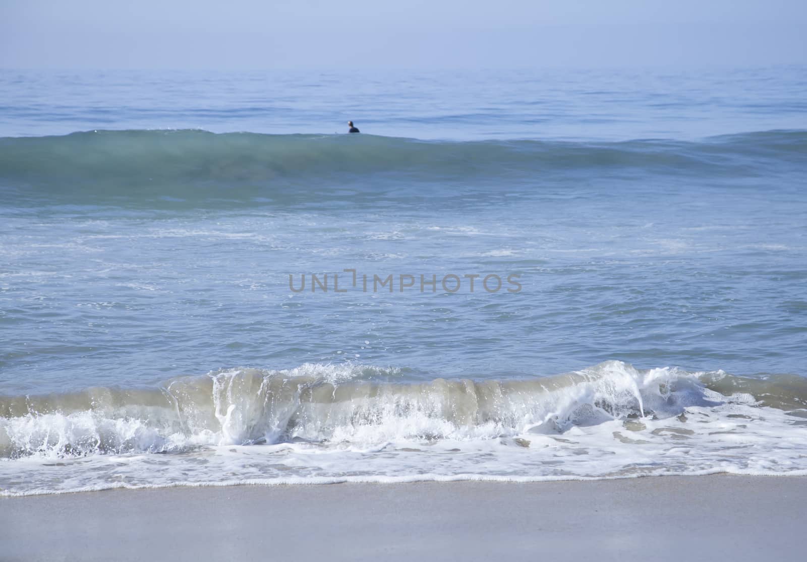 Heavy, foamy waves lapping at the ocean shore