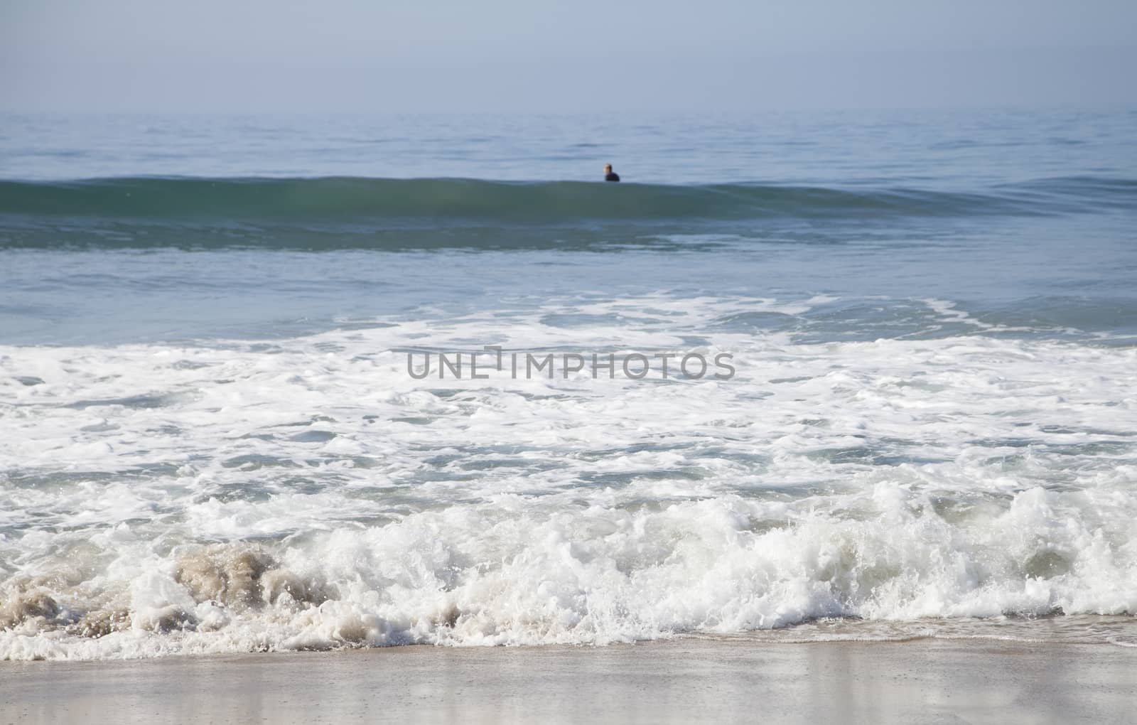 Heavy, foamy waves lapping at the ocean shore