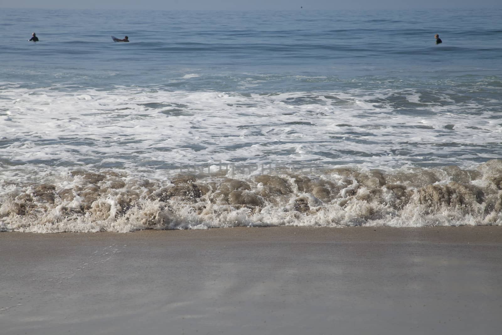 Heavy, foamy waves lapping at the ocean shore