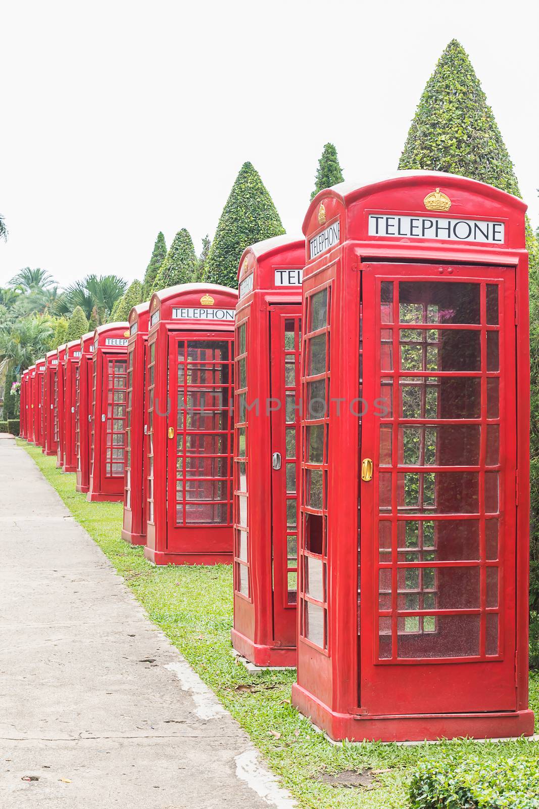 Row of classic British red telephone booth in garden