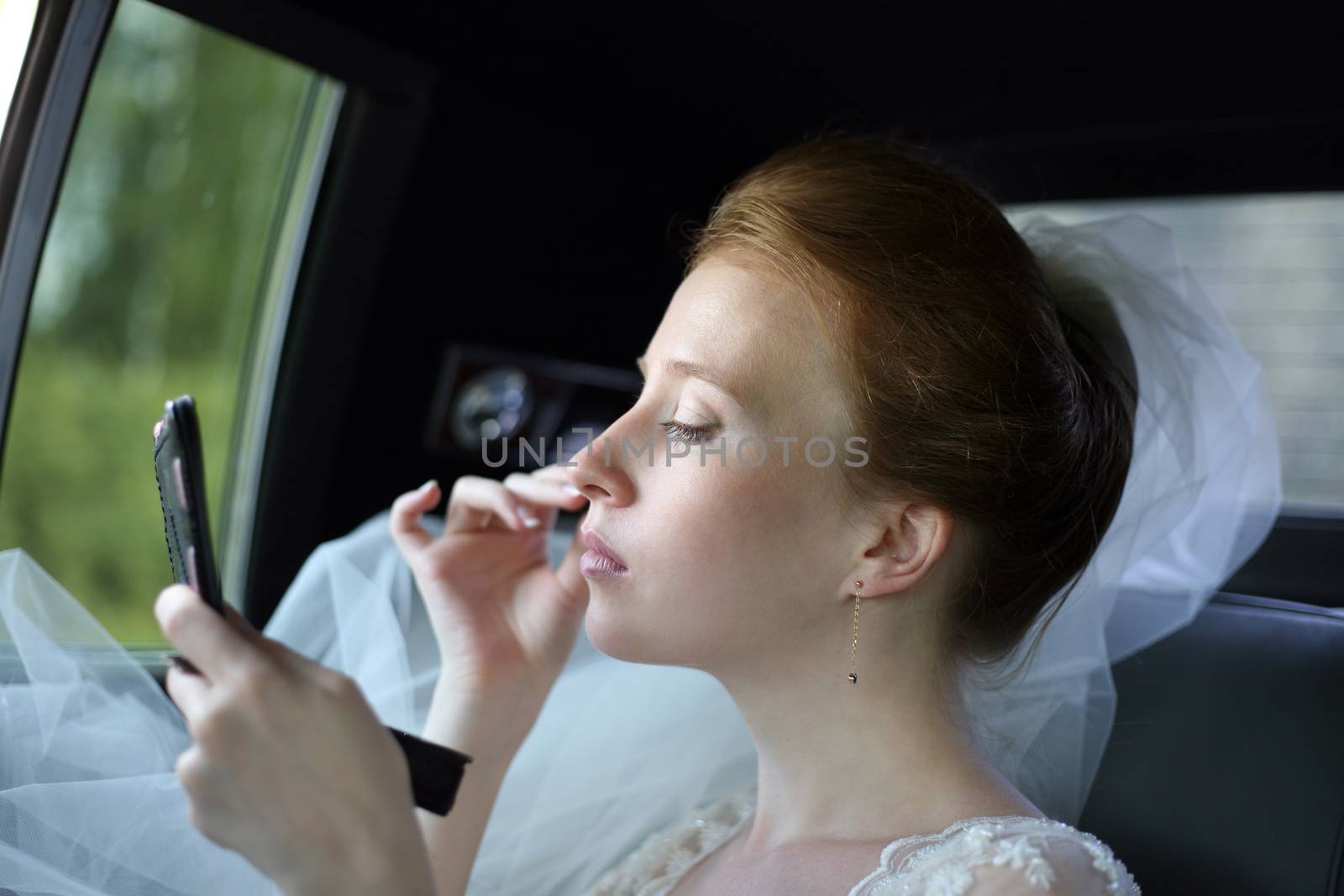 The beautiful bride in the automobile