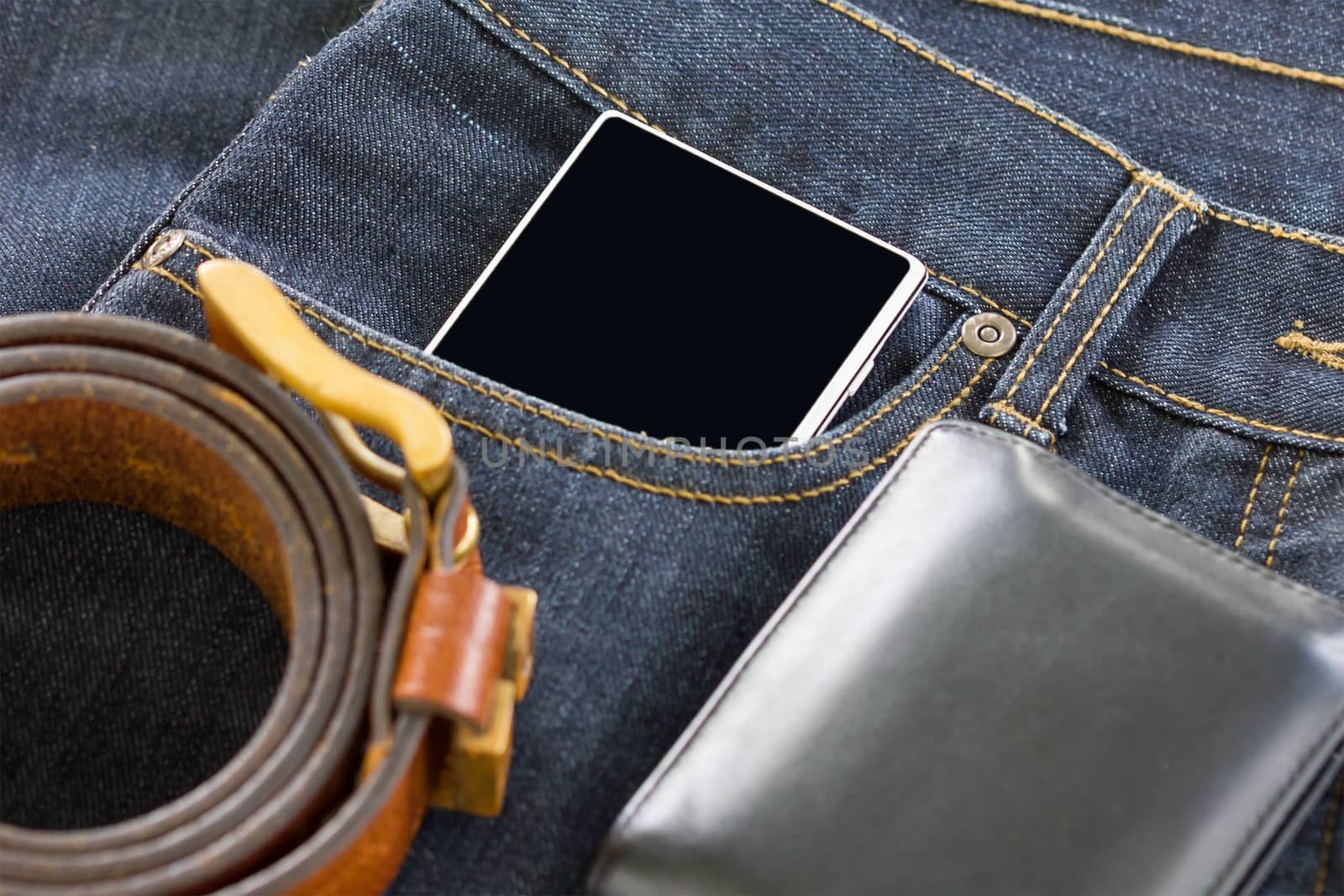 Wallet and smartphone on denim jeans by stoonn