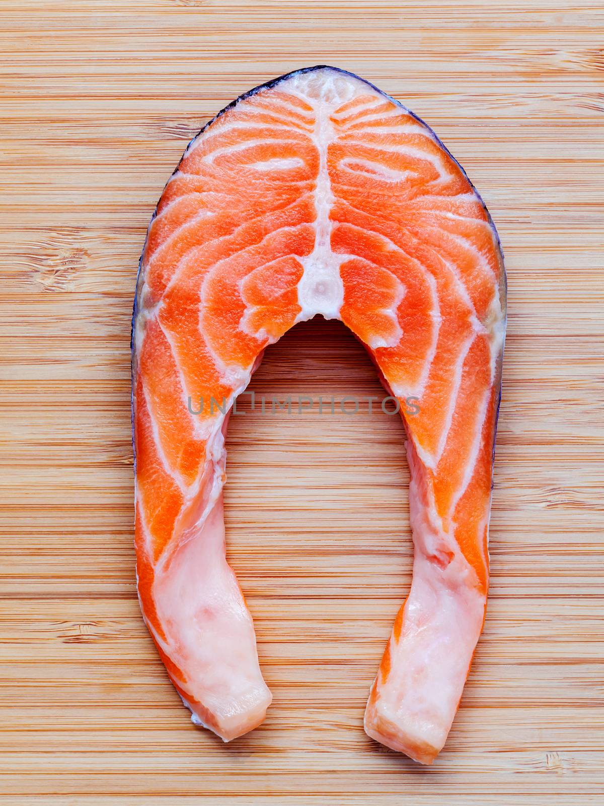 Fresh salmon fillet sliced flat lay on bamboo cutting board. Fresh salmon fillet sliced tempts buyers at fresh seafood stall.