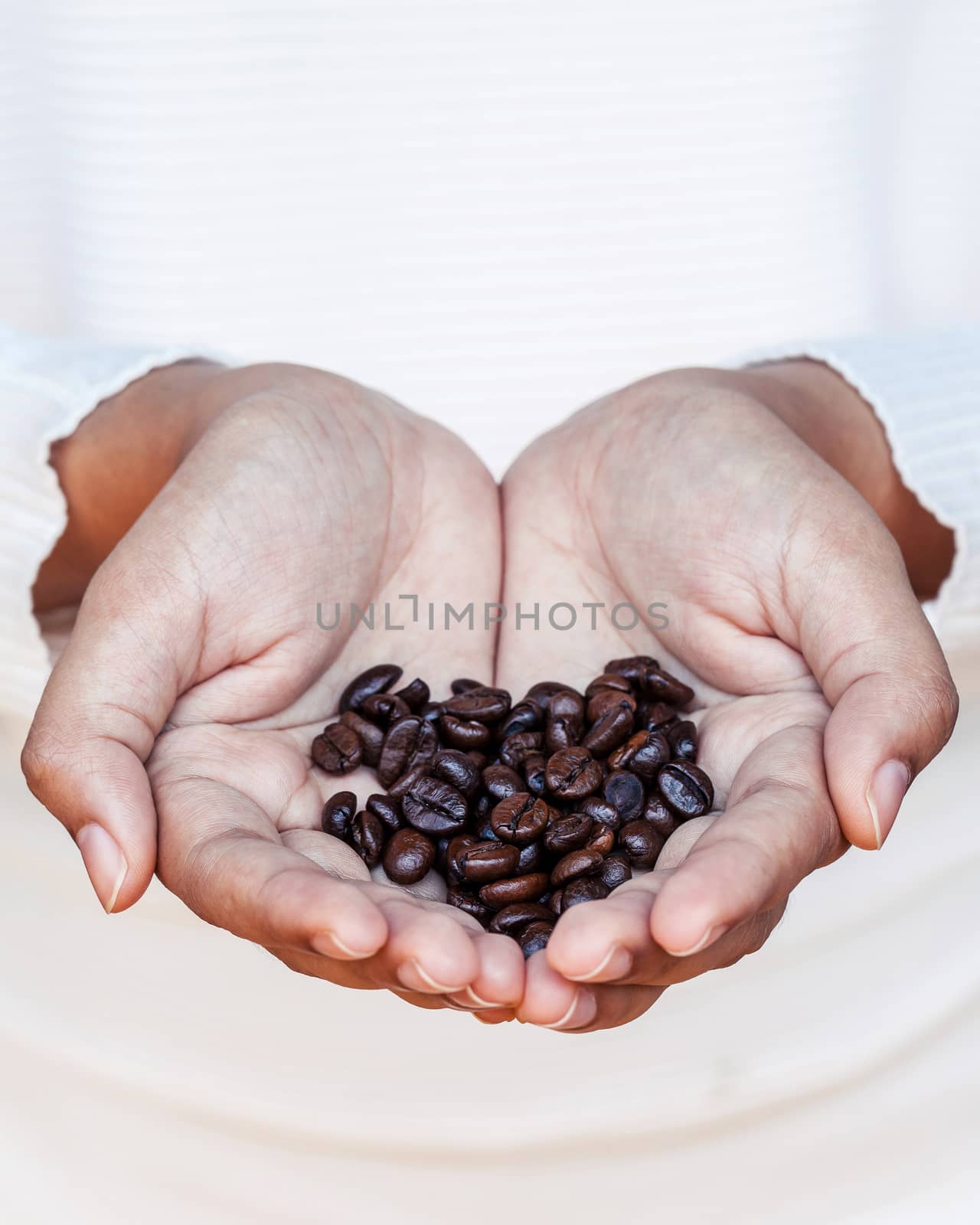 Closeup coffee bean in women hands concept for good morning and giving refreshing with shallow depth of field.