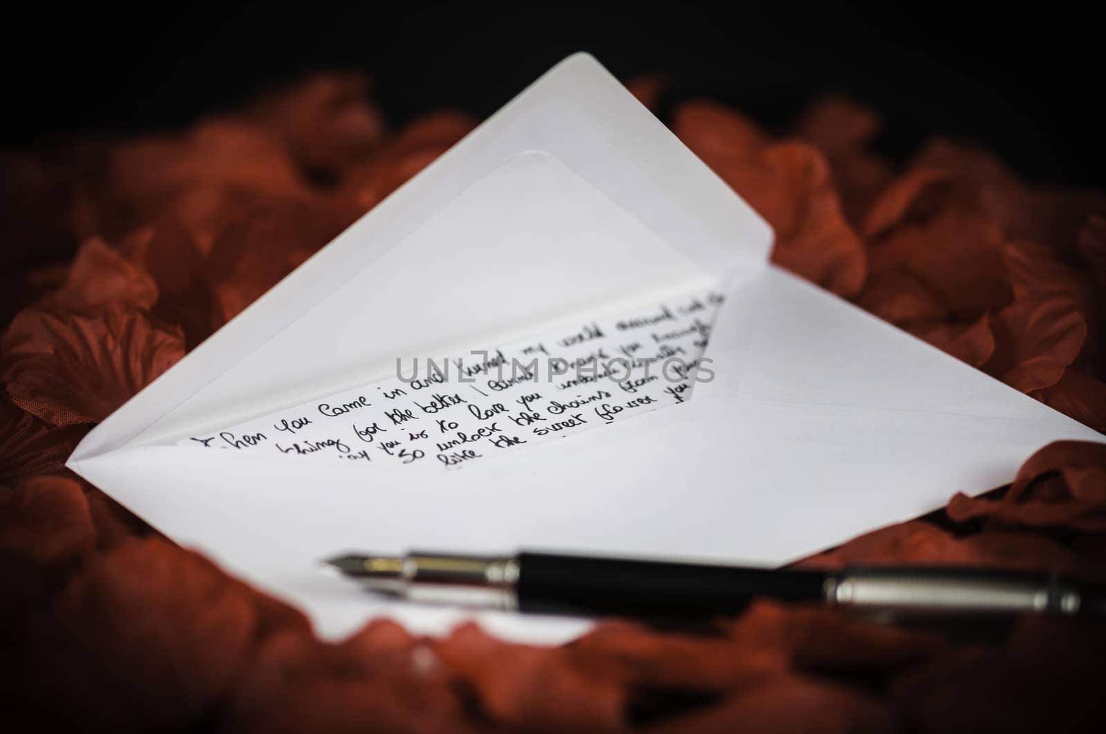 love letter on red rose petals and black background