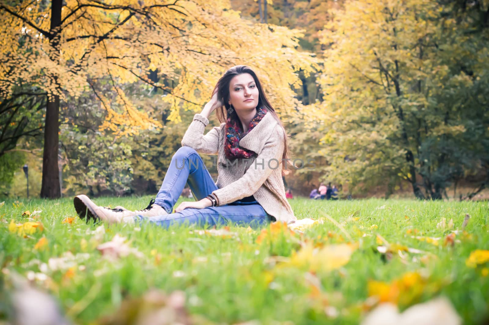 girl sitting on the grass in the autumn Park