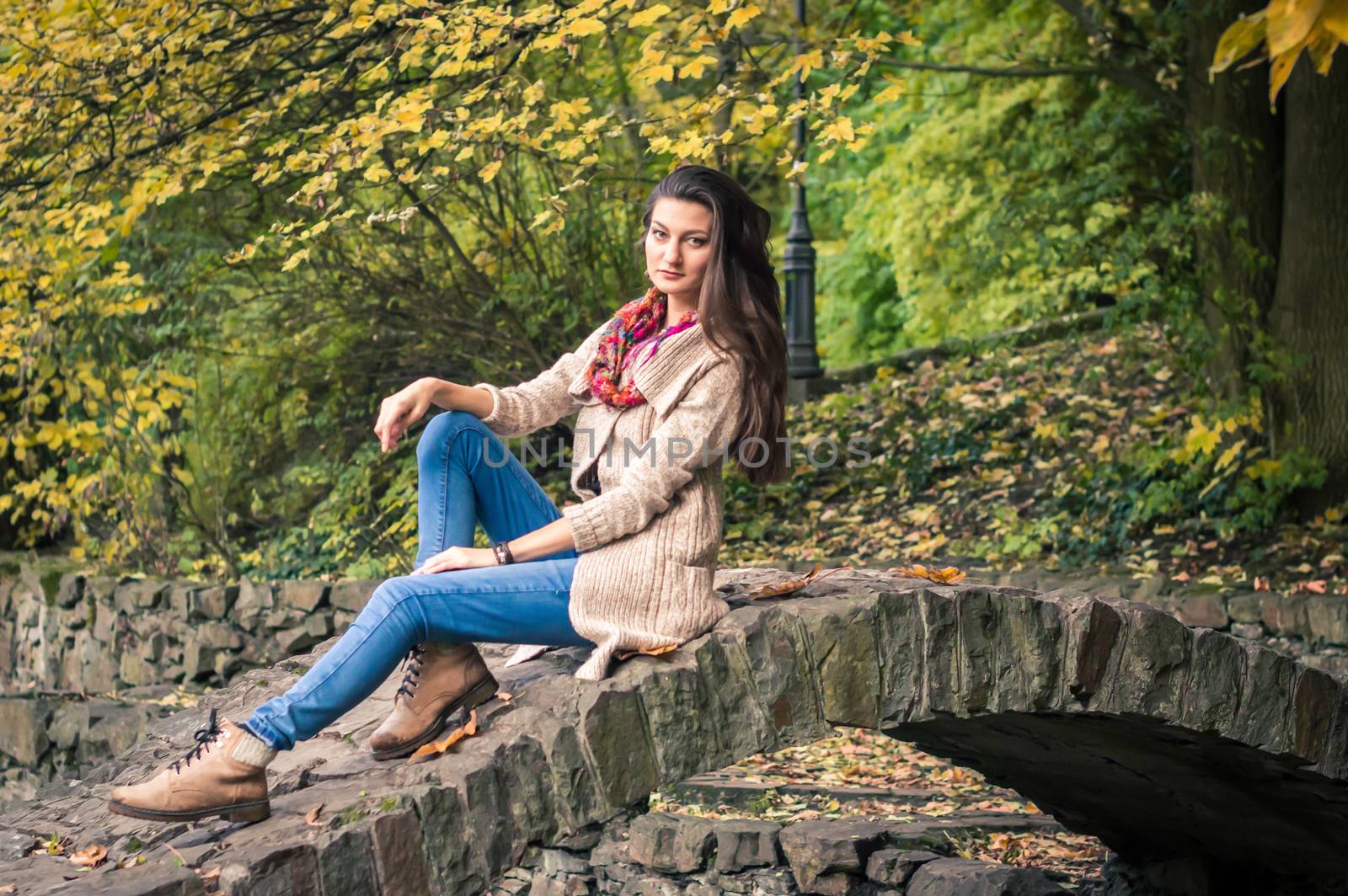 girl sitting on a stone bridge in the Park