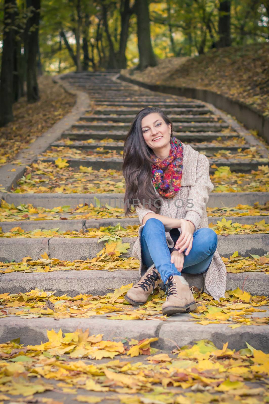 girl sitting on stone steps in autumn Park