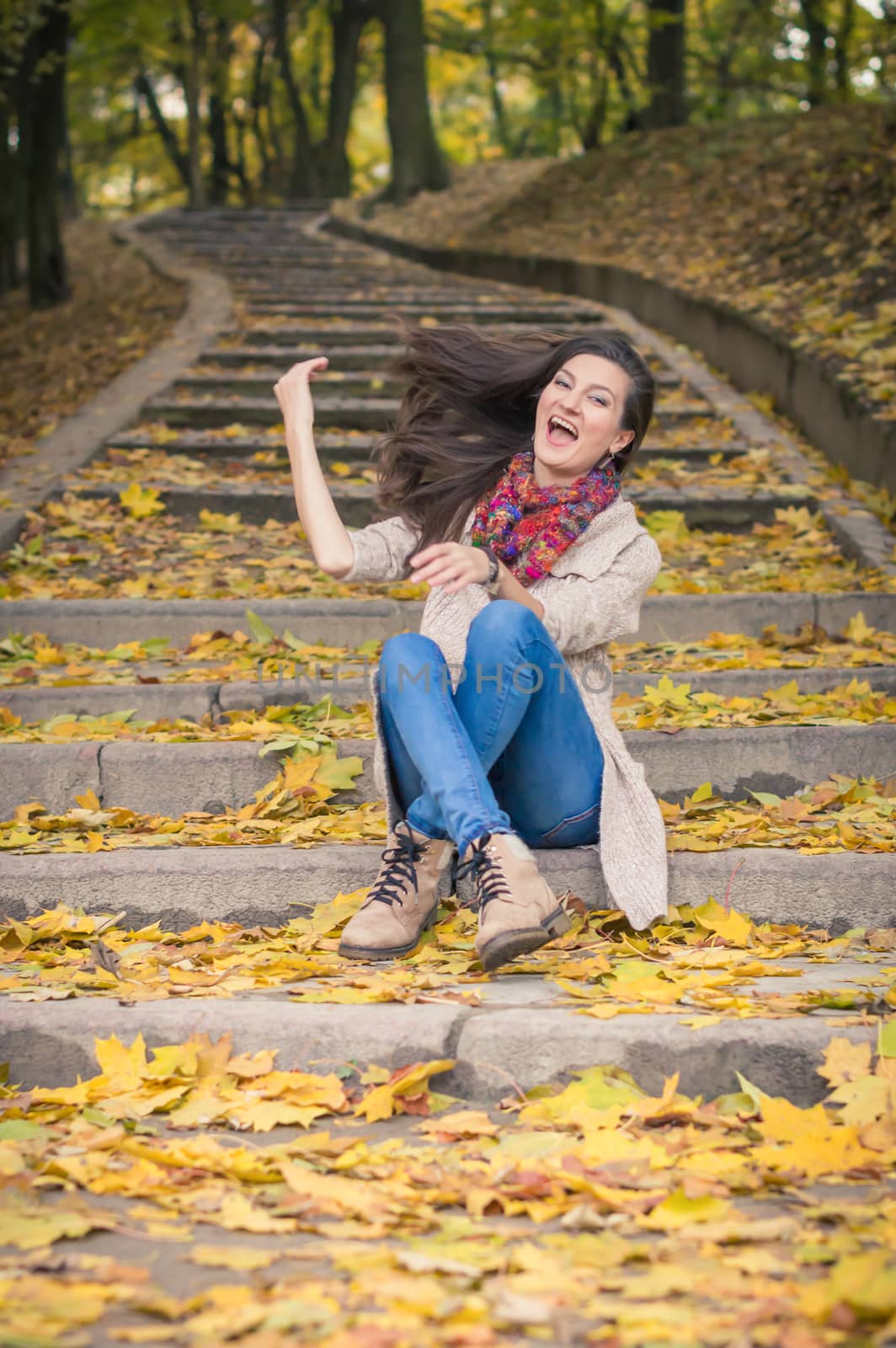 girl sitting on stone steps in autumn Park