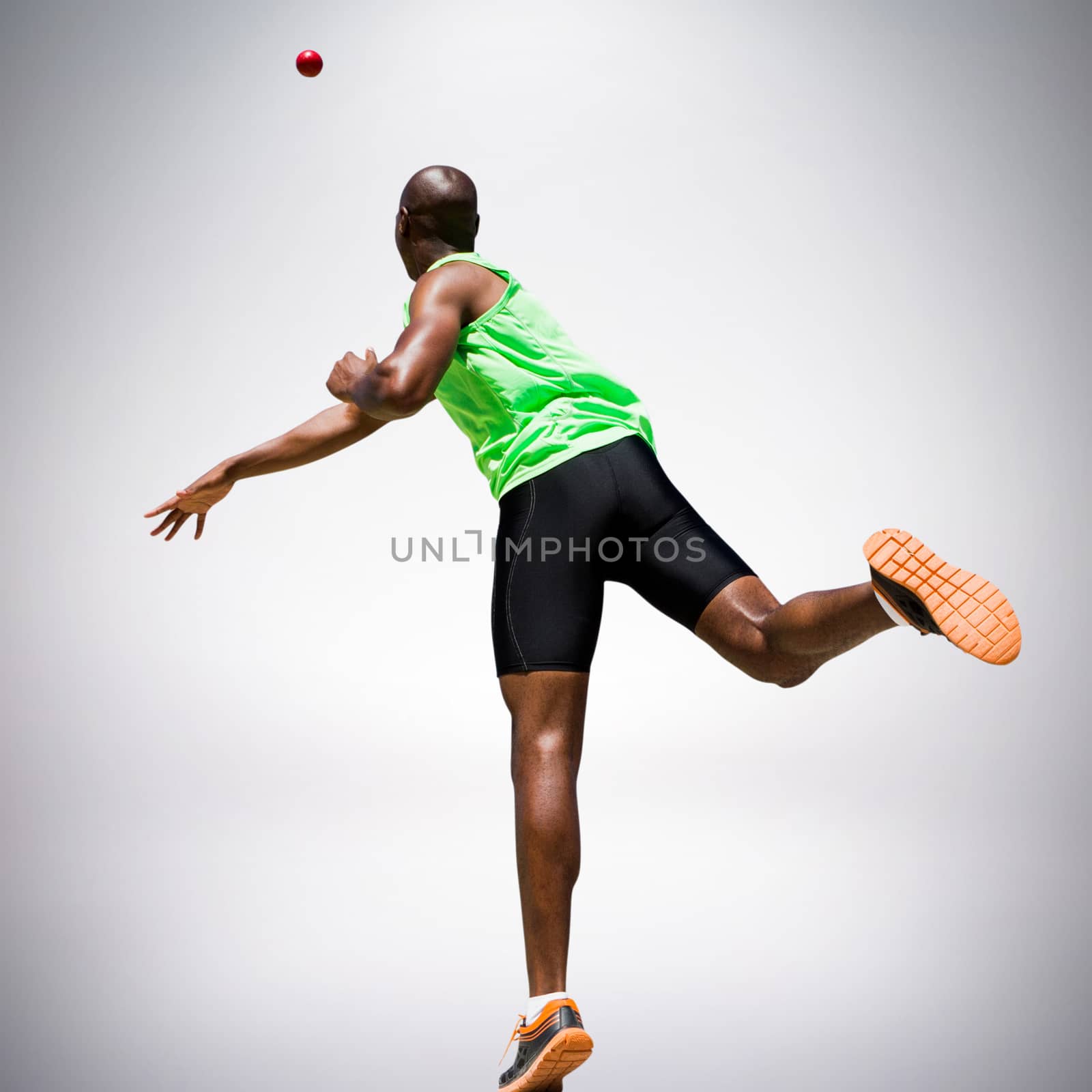 Rear view of sportsman throwing a shot against grey background