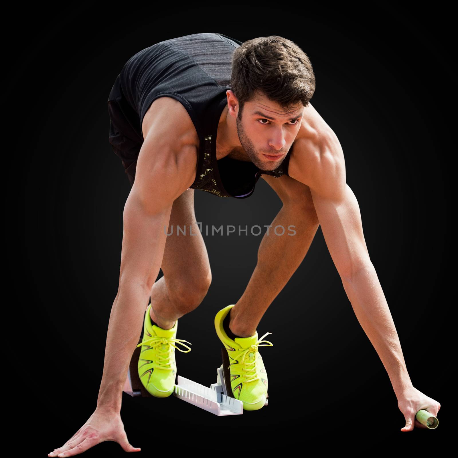 Portrait of sportsman waiting on the starting block in a black background