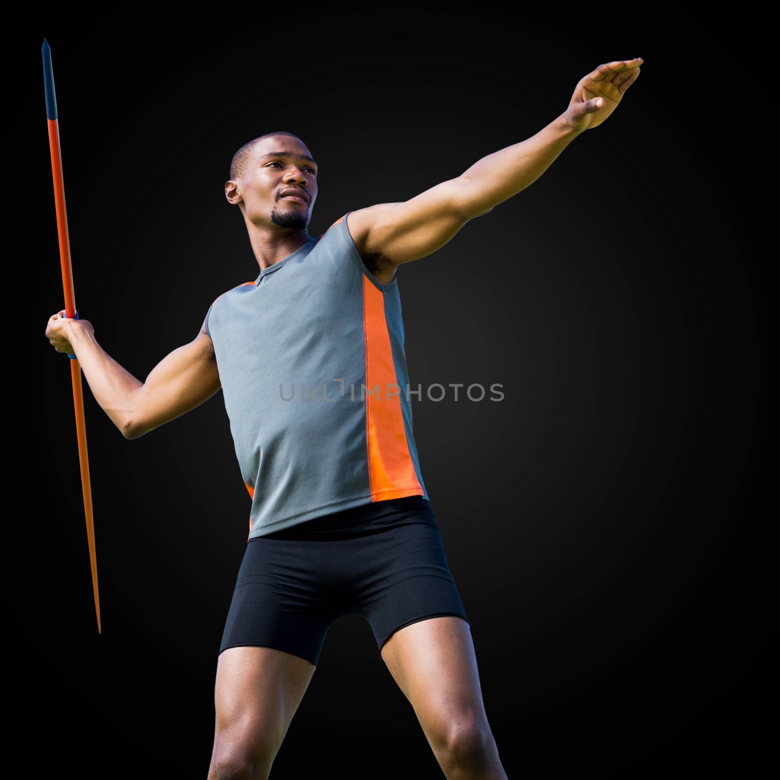 Sportsman practicing the javelin throw in a black background 