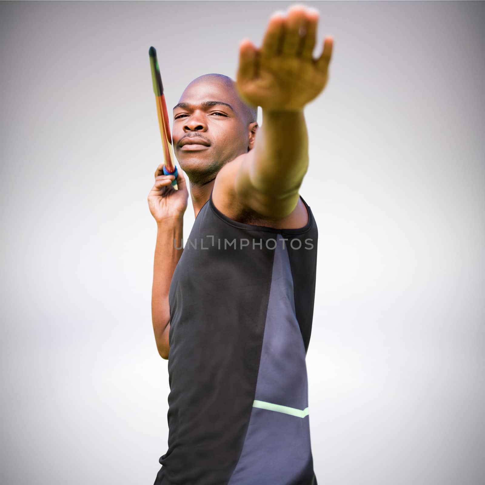 Portrait of sportsman practising a javelin throw against grey background