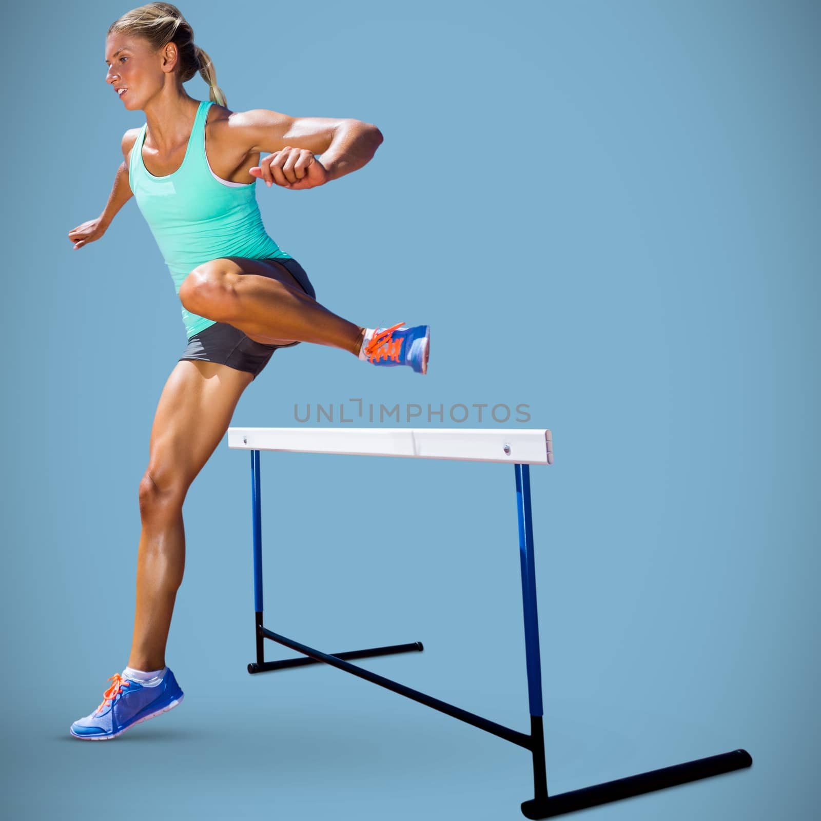 Sportswoman practising the hurdles against blue background